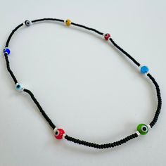 a black beaded necklace with evil eyes on it