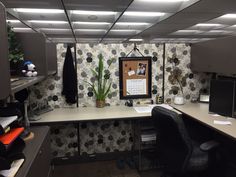 an office cubicle with desk, chair and computer on the wall next to it