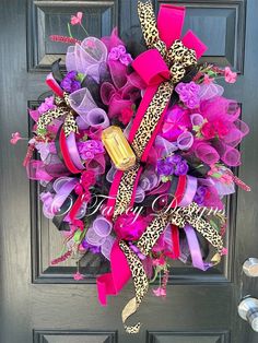 a purple wreath with leopard print, pink and purple flowers on the front door to a house