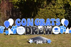 a graduation sign with balloons and confetti in the shape of stars on it