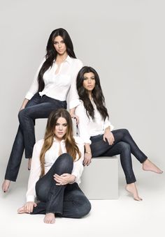 three beautiful young women sitting on top of a white box with the caption kardashian kollection denim