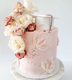 a pink cake with white flowers and a topper on the bottom is sitting on a plate