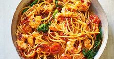 pasta with shrimp, asparagus and tomato sauce in a pan on a table