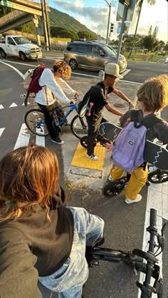 several people on bicycles waiting to cross the street