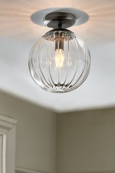 a light that is hanging from the ceiling in a room with white walls and flooring