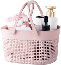 a pink basket with soap, lotion and other items in it on a white background