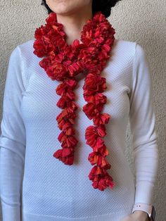 a woman wearing a white sweater and red flowered scarf