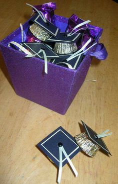 a purple gift box filled with chocolates on top of a wooden table next to a pair of scissors