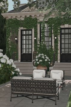 two wicker couches sitting in front of a house with white flowers on it