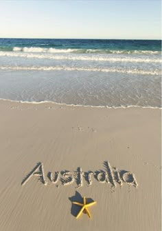 the word australia written in the sand with a starfish on it's side