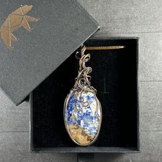 This stunning pendant features Sodalite in matrix, which helps reduce stress and anxiety. If you’re struggling with extra stress in your life, this beautiful pendant is for you! Wrapped by our exclusive artist, when properly cared for this 100% pure copper with patina pendant will stand the test of time and make you the envy of everyone that sees you wear it. Includes an 18” vegan leather waxed cord Lead-free; nickel-safe Pendant is 3.14" H (79.7mm) x 1.13" W (28.8mm) Comes in our exclusive luxury gift box Source: Unknown Handmade by Moonsong by LaLańya Includes Certificate of Authenticity Any visible imperfections and/or cracks are due to natural formation Product color may slightly vary due to photographic lighting sources! About Moonsong by LaLańya The night that Moonsong by LaLańya was Orange Stone, Book Jewelry, Clear Stone, Luxury Gift Box, Purple Stones, Source Unknown, Red Stone, Pink Stone, Grey Stone