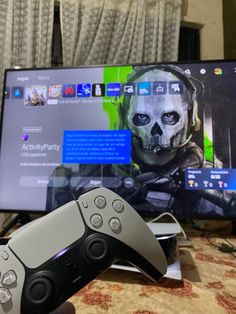 a person holding a video game controller in front of a computer screen with a skull on it