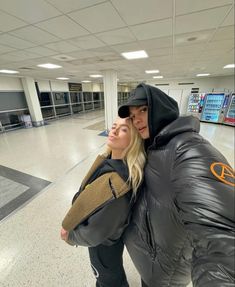 a man and woman standing next to each other in an airport