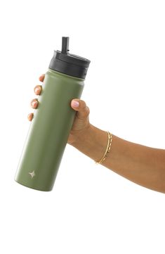 a hand holding a green water bottle with a black lid and gold chain around it