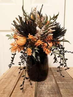 a vase filled with lots of different types of flowers on top of a wooden table