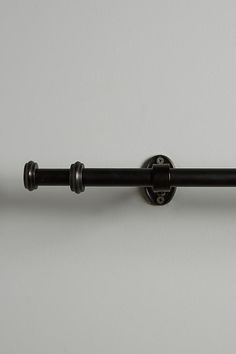 a black metal curtain rod on a white wall