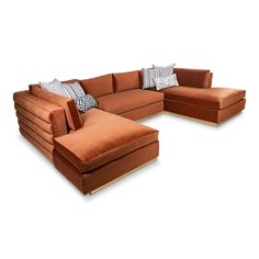 an orange sectional sofa with pillows on it