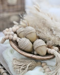 a wooden bowl filled with shells on top of a white table cloth next to other items