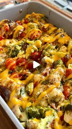 a casserole dish with broccoli, tomatoes and cheese