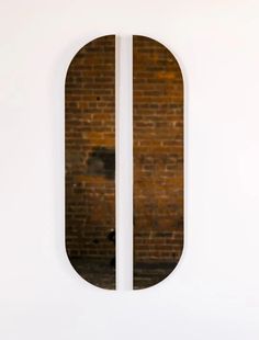 a brick wall with two circular mirrors on it