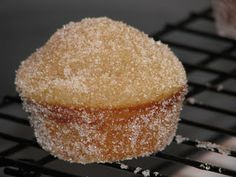 a muffin sitting on top of a cooling rack covered in powdered sugar next to another muffin