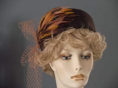 ON SALE ORIGINALLY $149.99 I have hand blocked this brown felt hat on a vintage block from Paris! I've added a beautiful feather pad with shades of brown, gold, and peachy salmon. A vintage veil piece in salmon has been added with a loop and long tails. I've hand stitched millinery wire at base to hold shape. This hat is entirely made by hand, with no machine stitching. Hand stitched grosgrain ribbon band inside for hat protection and comfort. Fit 21.5" to 22". Fitted Brown Costume Hats For Kentucky Derby, Brown Fitted Fascinator Hat, Brown Hat Fascinator For Kentucky Derby, Brown Short Brim Hat For Wedding, Brown Short Brim Wedding Hat, Vintage Brown Wedding Hat, Vintage Brown Mini Hat For Kentucky Derby, Brown Felt Hat, Hat French