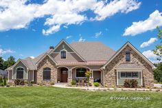 a large house with lots of windows on the front and side of it, surrounded by lush green grass