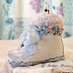 there is a white shoe with flowers on it and a small figurine in the middle