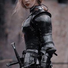 a woman dressed in black holding two swords