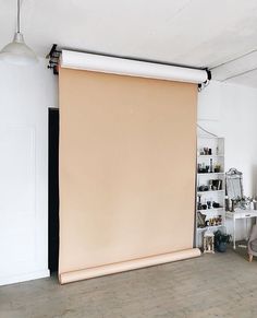 a living room with a large beige roller shade