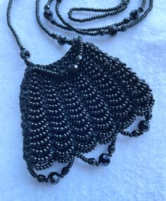 "A beautiful black knitted bag made by me with black Czech seed beads and all black accent beads. The bag feels wonderfully soft to touch. These are all good quality beads. No plastic!! The necklace strap measures 28\" The bag measures approx. 2 1/4\" x 2 3/4\"" Black Beaded Bags As Fashion Accessory, Black Beaded Bag As Fashion Accessory, Black Beaded Chain Necklaces For Evening, Evening Black Beaded Necklaces, Black Handmade Beaded Necklaces For Evening, Black Beaded Bags, Black Beaded Bag, Amulet Bag, Bag Necklace