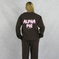 Alpha Phi crewneck sweatshirt is the unisex sorority sweatshirt to start your new school year. This brown, Alpha Phi sweatshirt has trending puff print in pink on the front and back. A new school year means new designs and this unisex, fleece Alpha Phi sweatshirt is part of our new 2024/2025 collection. This cute sorority sweatshirts unisex fit is the ultimate in comfort, warmth and sorority style. Wear this sorority top with everything from jean shorts to jeans, bike shorts to leggings or with the matching sweatpants. Alpha Phi Hoodie Sizing Model is 5'9", size 0/2, and wearing size M A Phi Hoodie Technical Details  - 7.6 oz./yd² (US), 12.7 oz/L yd (CA), 70/30 combed ring-spun cotton/recycled polyester, 31 single  - Reimagined, Recycled, ReFlex Fleece is the next evolution of fleece  - 3- Varsity Pink Sweatshirt For Streetwear, Crew Neck Sweats With Logo Print For College, Pink Varsity Sweatshirt For Streetwear, School Spirit Long Sleeve Sweatshirt With Logo, Pink College Sweatshirt With Letter Print, Pink Letter Print Sweatshirt For College, College Logo Print Sweatshirt, Pink College Sweatshirt With Ribbed Cuffs, Oversized School Spirit Sweatshirt For Campus