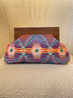 Enhance your accessories collection with the Threaded Clutch. Handmade with 100% cotton, this work of art features a colorful threaded design adorned with turquoise and coral colored beads. Complete with a wooden handle, this timeless bag will elevate your style and add a touch of 'world traveler' to any outfit. Size: 13 inches X 8.5 inches Handmade Multicolor Clutch For Summer, Multicolor Summer Festival Clutch, Traditional Handmade Beach Clutch, Summer Festival Multicolor Clutch, Multicolor Woven Bohemian Clutch, Multicolor Beach Clutch, Bohemian Multicolor Summer Clutch, Bohemian Multicolor Bag With Colorful Beads, Handmade Pink Bohemian Clutch