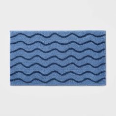 a blue bath mat with wavy waves on the front and back of it, against a white background