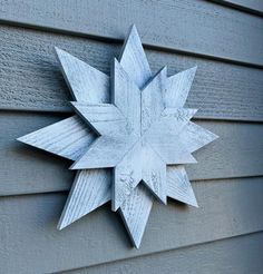 a white snowflake on the side of a gray house with wood sidings