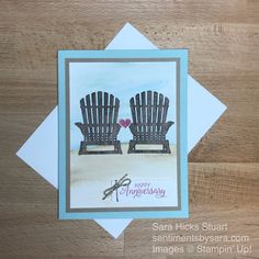 a card with two chairs sitting on top of a wooden table next to each other