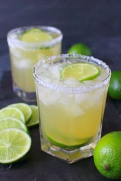 two glasses filled with lemonade and limes