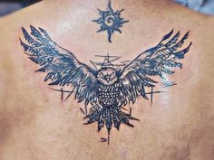 the back of a man with an owl and compass tattoo on his upper back shoulder