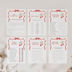 four red and white christmas themed baby shower games on a table with greenery in the background