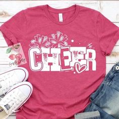 a red shirt with the word cheer written in white on it next to jeans and sneakers