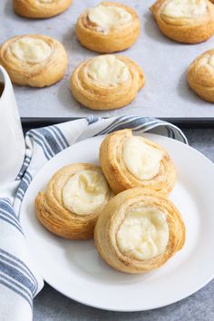 some cookies are sitting on a plate next to a cup of coffee and muffins