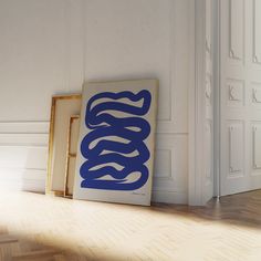 a blue and white painting sitting on top of a hard wood floor next to an open door