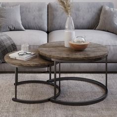 two tables sitting in front of a gray couch