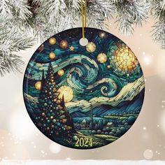 a christmas ornament hanging from a tree with the night sky and stars painted on it