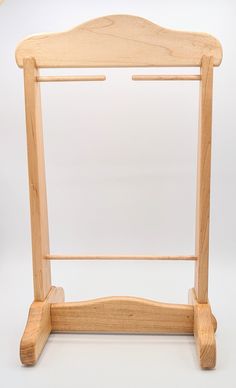 a wooden frame with two legs and a coat hanger on the bottom one side