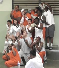 a group of people in orange and white outfits posing for a photo with each other