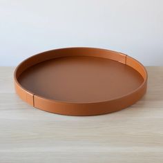 a round tray on a wooden table with a white wall in the backround