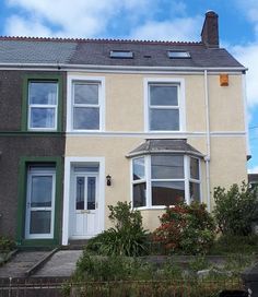 a two story house with white windows and green trim