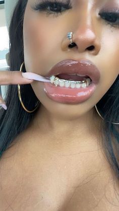 a close up of a person brushing her teeth with an electric toothbrush in their mouth