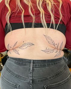 the back of a woman's stomach with leaves tattooed on her lower body and bottom